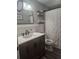 Well-lit bathroom features a modern vanity, decorative mirror, and a stylish shower curtain at 5710 Broadway Ave, New Port Richey, FL 34652