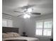 Cozy bedroom features a ceiling fan and plantation shutters, creating a warm and inviting ambiance at 5710 Broadway Ave, New Port Richey, FL 34652