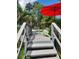Inviting deck featuring gray wood planks, a bright red umbrella, and a comfy green Adirondack chair at 5710 Broadway Ave, New Port Richey, FL 34652