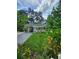 Inviting single-Gathering home featuring a driveway, carport, manicured lawn, and lush landscaping at 5710 Broadway Ave, New Port Richey, FL 34652