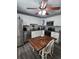 Bright kitchen boasts white cabinets, stainless steel appliances, and a cozy dining area with a wooden table at 5710 Broadway Ave, New Port Richey, FL 34652