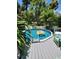 Backyard pool featuring a deck with lounge chairs and lush tropical landscaping at 5710 Broadway Ave, New Port Richey, FL 34652