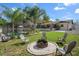 Inviting backyard featuring a fire pit, lush landscaping, and a screened-in pool, perfect for relaxation and entertaining at 6347 Shadydale Ave, Spring Hill, FL 34609