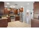 Modern kitchen with stainless steel appliances, granite counters and brown cabinets at 6347 Shadydale Ave, Spring Hill, FL 34609