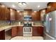 Bright kitchen with stainless appliances, tile backsplash, granite countertops and brown cabinets at 6347 Shadydale Ave, Spring Hill, FL 34609