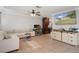 Cozy living room showcasing tiled floors, modern furniture, ceiling fan, and open layout at 6347 Shadydale Ave, Spring Hill, FL 34609