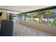 Enclosed patio space with brick flooring, grill and view of the backyard at 6347 Shadydale Ave, Spring Hill, FL 34609