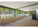 Covered outdoor patio with a screened enclosure and brick flooring at 6347 Shadydale Ave, Spring Hill, FL 34609