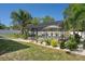 The screened-in pool is framed by tropical foliage, a white fence, and a landscaped yard for a serene retreat at 6347 Shadydale Ave, Spring Hill, FL 34609