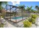 This screened-in pool area is enhanced by tropical landscaping and a partially shaded deck for poolside relaxation at 6347 Shadydale Ave, Spring Hill, FL 34609