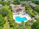 An aerial view of a community pool with a unique shape, seating, and lush greenery at 6462 River Run Blvd, Weeki Wachee, FL 34607