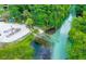 A scenic aerial view shows a sandy beach with lounge chairs and a clear, flowing river perfect for swimming at 6462 River Run Blvd, Weeki Wachee, FL 34607