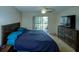 Comfortable bedroom with a spacious bed, balcony access, and a dresser, providing ample storage and relaxation at 6462 River Run Blvd, Weeki Wachee, FL 34607