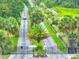 Gated community entrance with lush landscaping, palm trees, and a paved road at 6462 River Run Blvd, Weeki Wachee, FL 34607