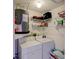 Practical laundry area with white washer and dryer, shelves for storage, and water heater at 6462 River Run Blvd, Weeki Wachee, FL 34607