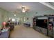 Cozy living room with an entertainment center, ceiling fan, and views of the kitchen and breakfast bar at 6462 River Run Blvd, Weeki Wachee, FL 34607