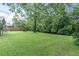 Expansive backyard featuring a lush lawn and scenic creek view, enhanced by mature trees and a wooden fence at 7230 Hummingbird Ln, New Port Richey, FL 34655