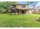 Large backyard featuring a lush lawn, covered patio, storage shed, and inviting fire pit for outdoor enjoyment at 7230 Hummingbird Ln, New Port Richey, FL 34655