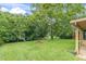 Beautiful backyard featuring lush green lawn, mature trees, and a charming fire pit perfect for outdoor gatherings at 7230 Hummingbird Ln, New Port Richey, FL 34655