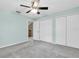 Bedroom featuring a ceiling fan, three closets, and a doorway to another room at 7230 Hummingbird Ln, New Port Richey, FL 34655