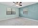 Bedroom with a ceiling fan, and two windows that provide plenty of natural light at 7230 Hummingbird Ln, New Port Richey, FL 34655