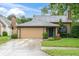 Inviting exterior showcasing a well-manicured lawn, mature landscaping, and a two-car garage at 7230 Hummingbird Ln, New Port Richey, FL 34655