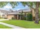 Charming home featuring a well-maintained lawn, mature trees, and an inviting front entrance at 7230 Hummingbird Ln, New Port Richey, FL 34655