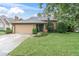 Charming single-story home featuring a well-maintained lawn, a two-car garage, and traditional architectural details at 7230 Hummingbird Ln, New Port Richey, FL 34655