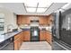 Well-lit kitchen featuring stainless steel appliances, granite countertops, and wood cabinets at 7230 Hummingbird Ln, New Port Richey, FL 34655