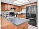Kitchen featuring a large island, stainless steel appliances, dark countertops and ample cabinet space at 7230 Hummingbird Ln, New Port Richey, FL 34655