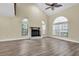 Bright living room with wood floors, a fireplace, vaulted ceiling, and large windows at 7230 Hummingbird Ln, New Port Richey, FL 34655
