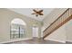 Bright living room with wood floors, a staircase, vaulted ceiling, and large windows at 7230 Hummingbird Ln, New Port Richey, FL 34655