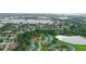 Aerial view of a community and surrounding greenery, pond, and distant cityscape at 7700 Danube Dr # 7700, Hudson, FL 34667