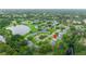 Community aerial view with lush trees, pond, and well-maintained landscaping at 7700 Danube Dr # 7700, Hudson, FL 34667