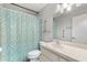 Well-lit bathroom featuring a shower with a blue mosaic curtain and white vanity at 7700 Danube Dr # 7700, Hudson, FL 34667