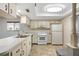 Bright kitchen featuring white cabinets, classic appliances, and durable flooring at 7700 Danube Dr # 7700, Hudson, FL 34667