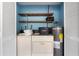 Laundry area with appliances, shelves, and blue wall at 7700 Danube Dr # 7700, Hudson, FL 34667