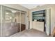Enclosed porch area featuring sliding glass doors with laundry machines and shelving for extra storage at 7700 Danube Dr # 7700, Hudson, FL 34667
