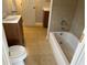 A bathroom featuring a toilet, vanity, and tub with tiled walls at 7714 Fox Hollow Dr, Port Richey, FL 34668