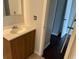 A bathroom with a wooden vanity and sink, adjacent to another room at 7714 Fox Hollow Dr, Port Richey, FL 34668