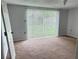 Bedroom featuring carpeted floors and sliding glass doors at 7714 Fox Hollow Dr, Port Richey, FL 34668
