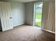 Bedroom featuring carpeted floors and a sliding glass door to the backyard at 7714 Fox Hollow Dr, Port Richey, FL 34668