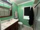 Cozy bathroom featuring a single sink vanity, window, and shower at 8122 Matthew Dr, New Port Richey, FL 34653