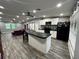 Open-concept kitchen with a large island, black countertops, white cabinets, stainless appliances, and black refrigerator at 8122 Matthew Dr, New Port Richey, FL 34653