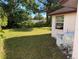 Exterior shot of the home's grassy backyard with surrounding trees at 8516 Inwood Dr, Hudson, FL 34667