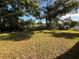 Exterior shot of the home's spacious backyard with surrounding trees at 8516 Inwood Dr, Hudson, FL 34667