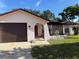 Charming home featuring an arched entryway with a wrought iron gate and a one-car garage at 8516 Inwood Dr, Hudson, FL 34667