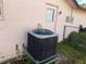 Exterior shot of the home's AC unit on the side of the house near a small grassy area at 8516 Inwood Dr, Hudson, FL 34667