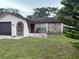 Modest single-story home featuring a stone accent wall and an arched entry at 8516 Inwood Dr, Hudson, FL 34667