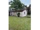 Rear side view of single-story home with a stone facade and chain link fence at 8516 Inwood Dr, Hudson, FL 34667